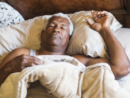 older black man sleeping in bed