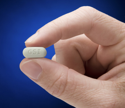 Genvoya pill held between two fingers