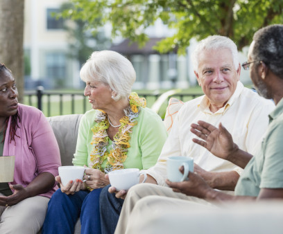 Two older couples hanging out on patio