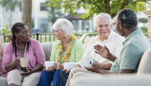 Two older couples hanging out on patio